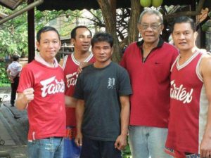 Phaiboon (center) standing with fellow friends and coworkers from Fairtex