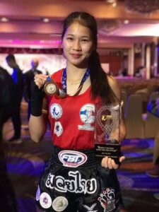 Buakaw Mor Kor Chor Chaiyaphum in 2018. Pictured with her Best Wai Kru Award and gold medal from the Asian Muaythai Championships. lumpinee first woman females muay thai muay ying