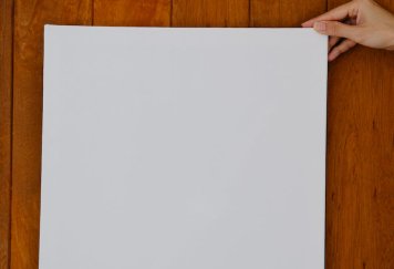 crop unrecognizable woman demonstrating blank canvas