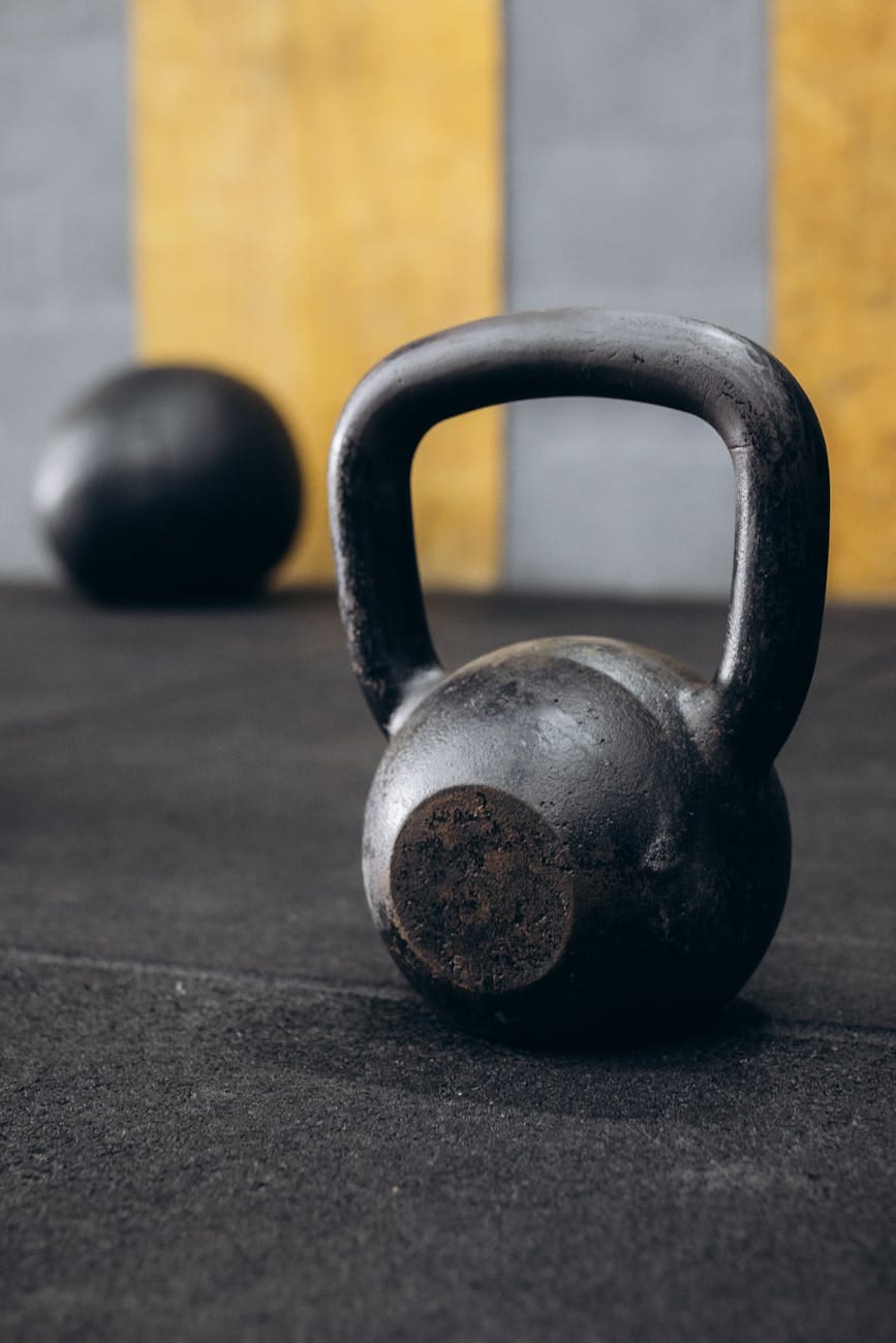 a kettlebell on a black background with two balls