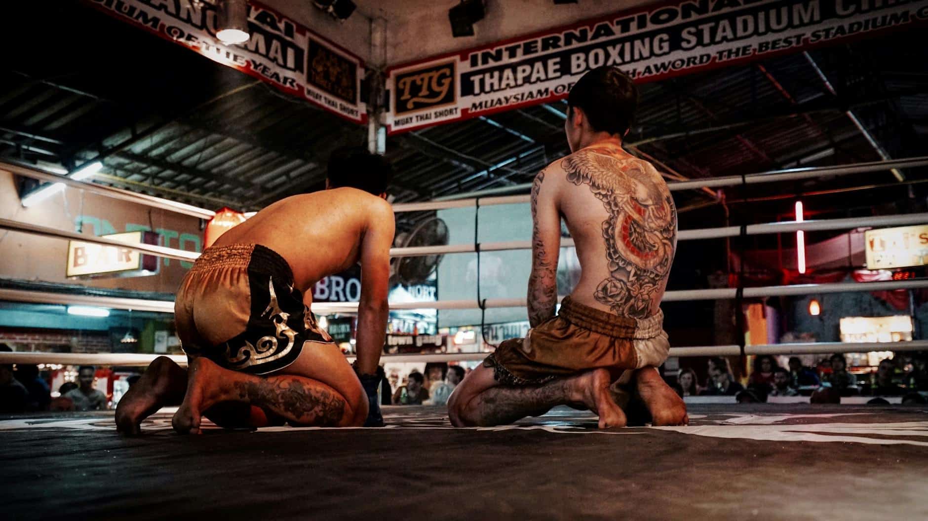 man kneeling on boxing ring
