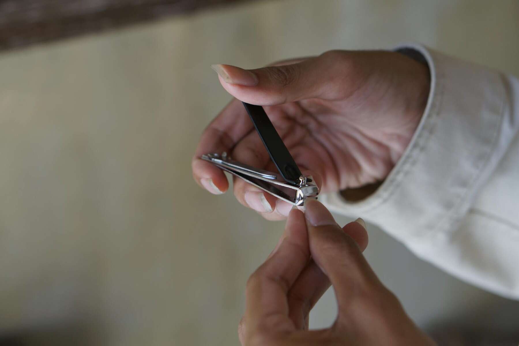 close up of a man cutting his fingernail using nail clipper