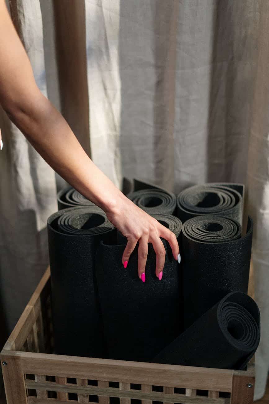 person holding black speaker on brown wooden table