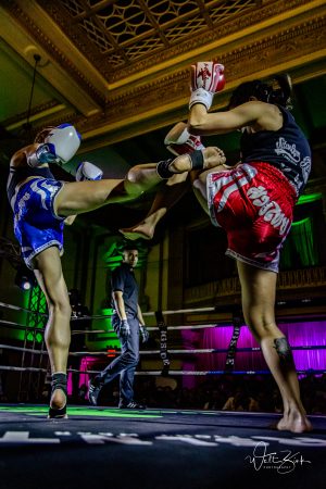 fighter blocks kick by opponent in ring