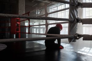 person sitting on the side of the boxing ring